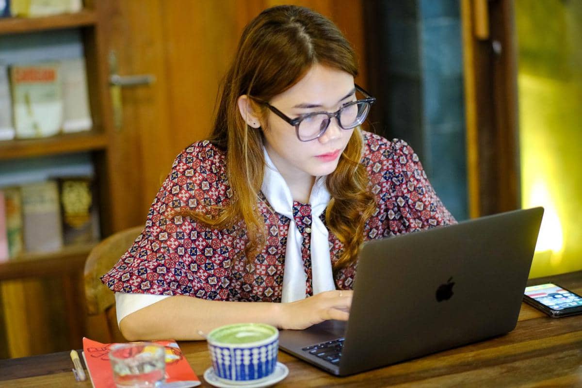 Ilustrasi seseorang bekerja menggunakan laptop di meja, menggambarkan aktivitas profesional dan produktivitas sehari-hari.