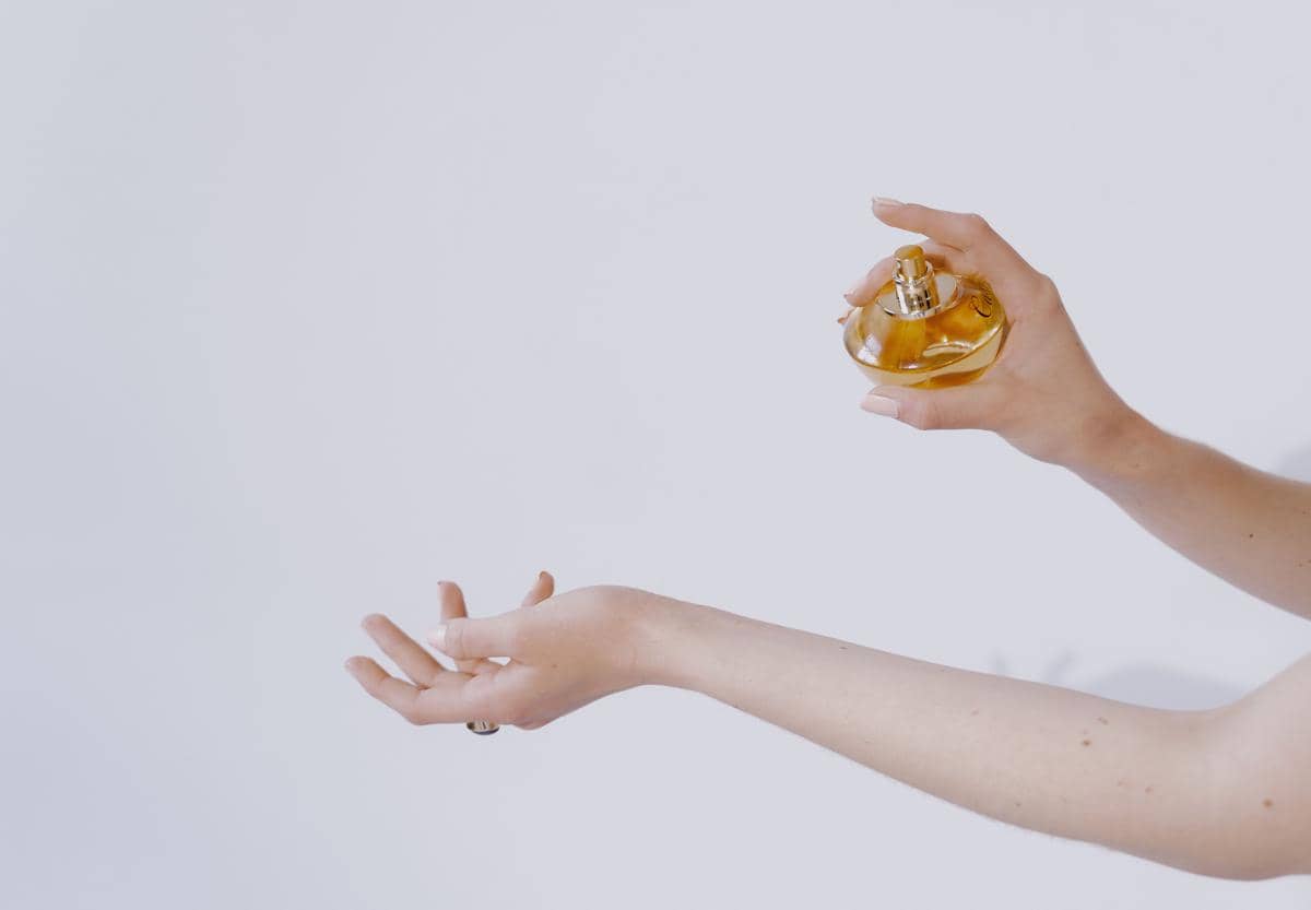 Ilustrasi tangan menyemprotkan parfum ke pergelangan tangan