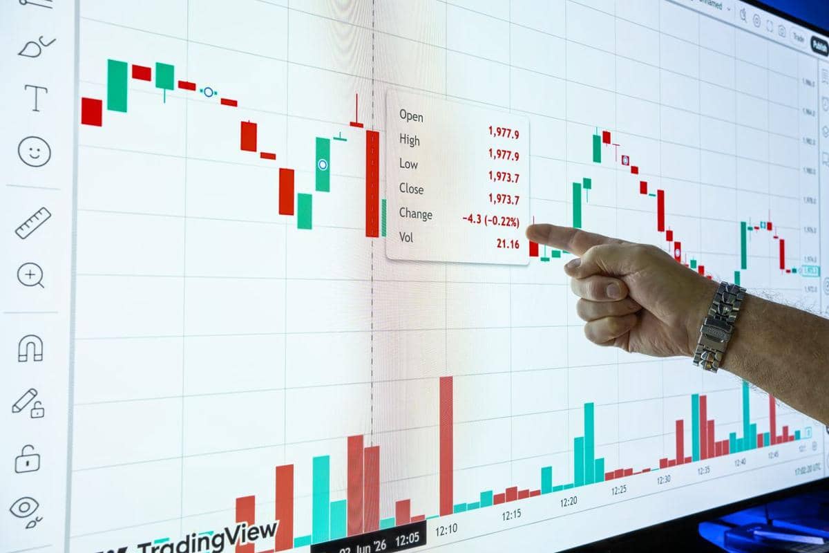 ilustrasi seseorang yang menunjuk grafik di layar yang menampilkan data keuangan