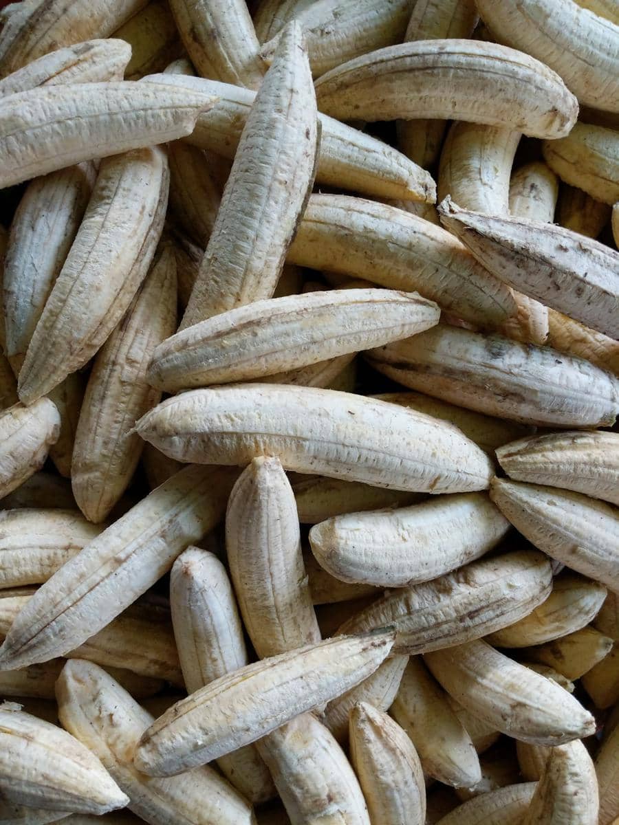 Ilustrasi pisang kuning matang yang telah dikupas, dengan kulit terbuka mengelilingi bagian buah berwarna pucat.