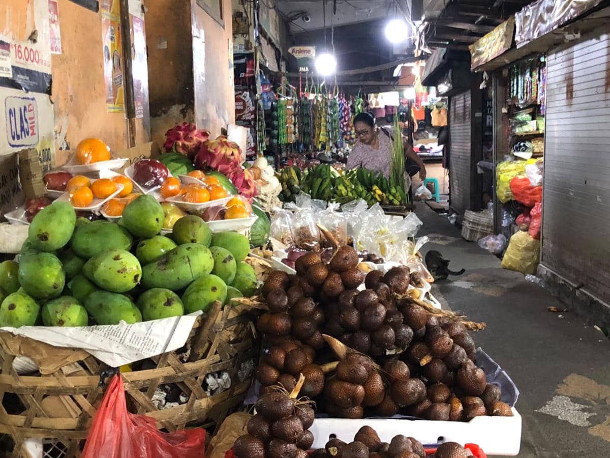 Suasana pasar tradisional di Tabanan dengan pedagang dan pengunjung beraktivitas di area jual beli.