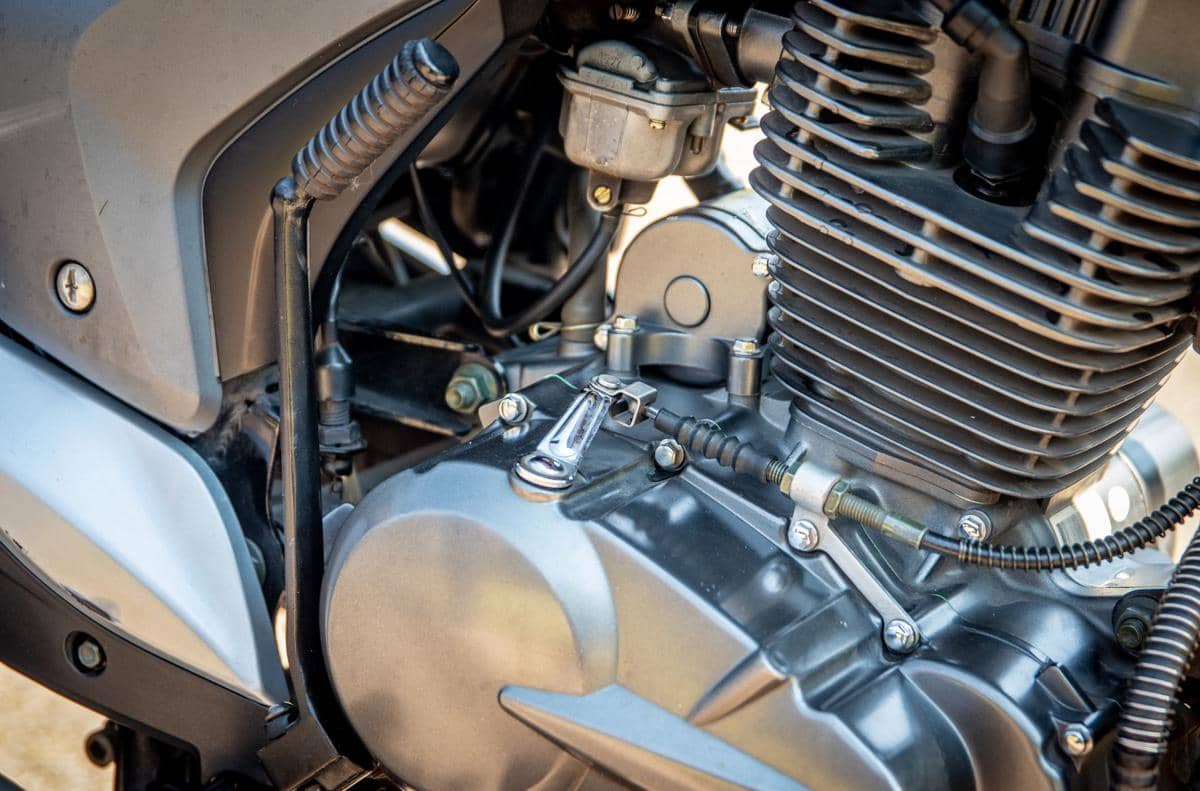 Ilustrasi mesin motor dengan susunan komponen logam dan detail mekanis sebagai gambaran perawatan kendaraan roda dua.