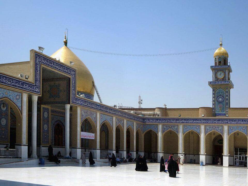 Bagian interior Masjid Agung Kufa yang memuat beberapa makam, dengan ornamen arsitektur Islam pada dinding dan langit-langit.