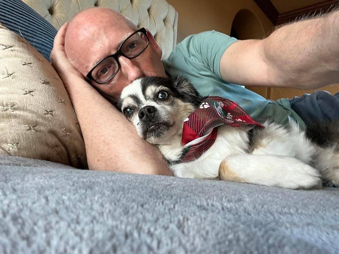 Scott Adams tampak beristirahat bersama anjing bernama Snickers dalam unggahan akun Instagram miliknya.