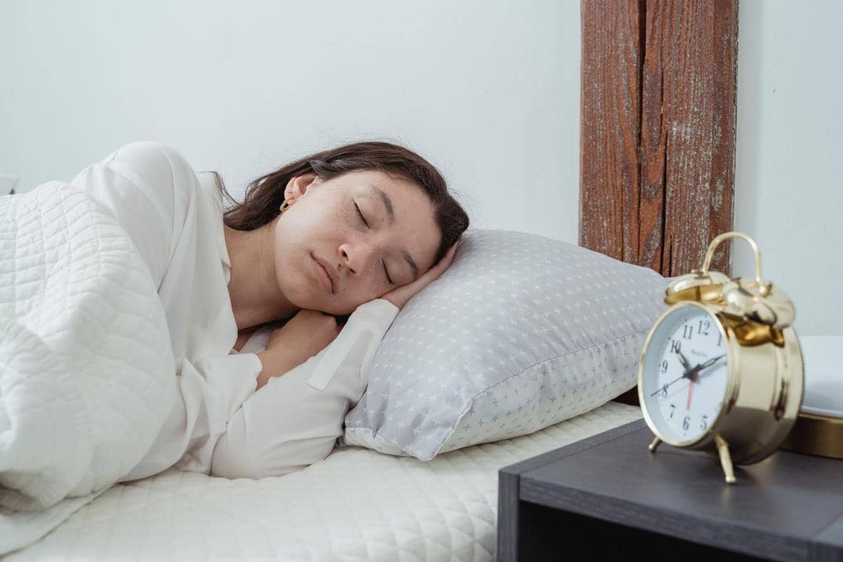 ilustrasi jam weker dan orang tidur di kamar