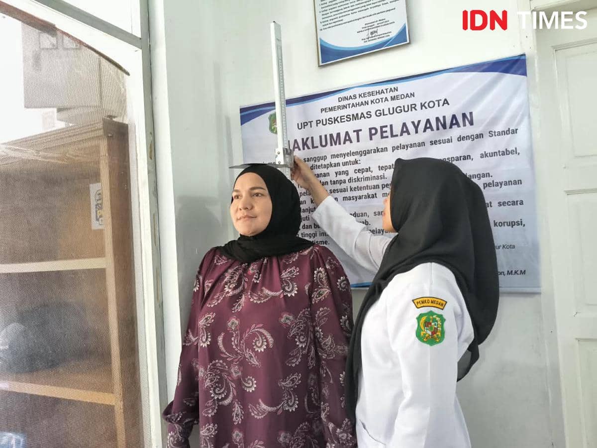 Ilustrasi petugas kesehatan memeriksa warga dalam layanan Cek Kesehatan Gratis di Puskesmas Glugur Kota, Medan.