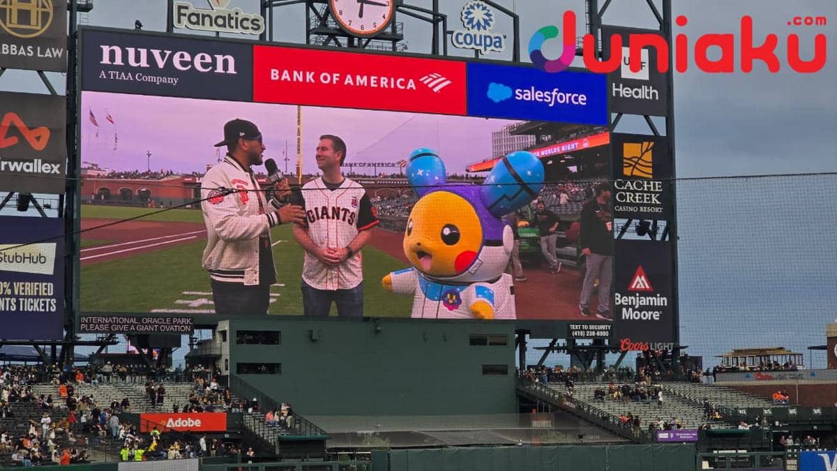 Chris Brown dari Pokémon menjalani wawancara di Oracle Park, San Francisco, dalam suasana pertunjukan drone malam hari.