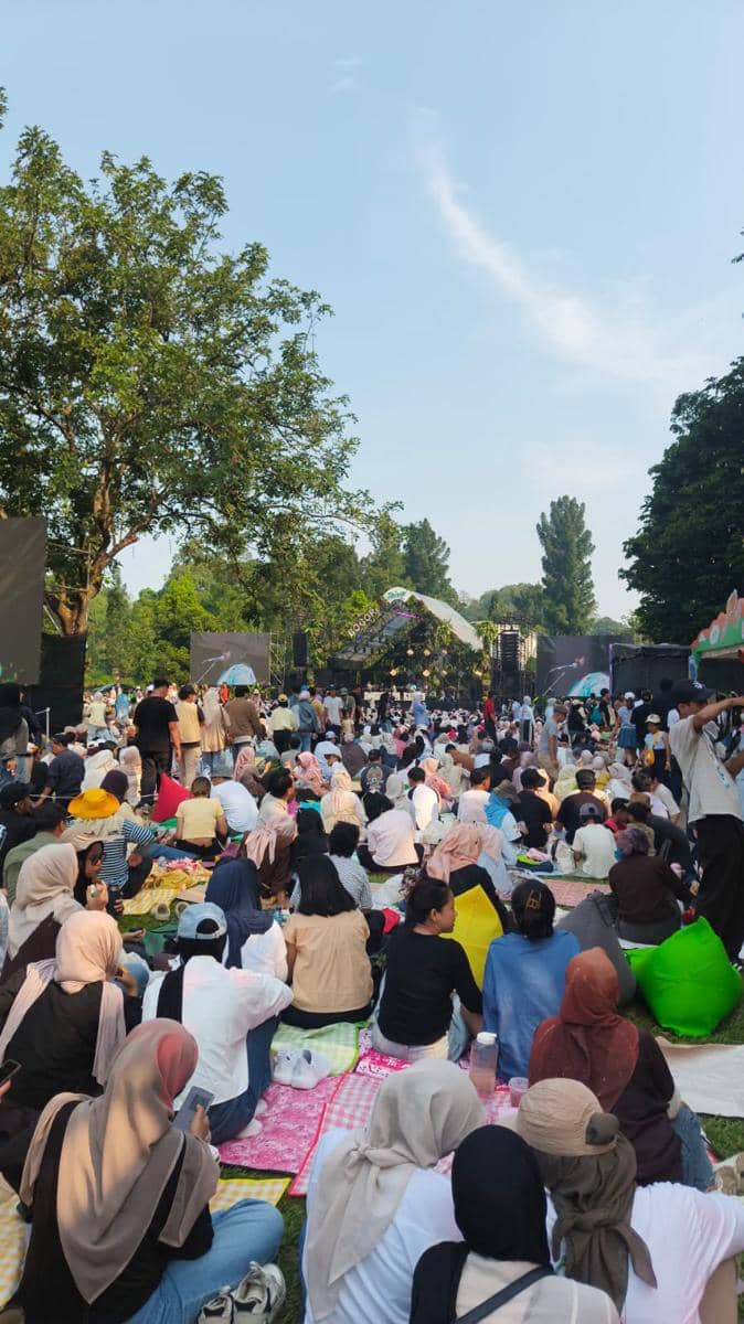 Pengunjung berinteraksi dengan pengisi acara pada kegiatan Sunset di Kebun dalam suasana acara yang ramai.
