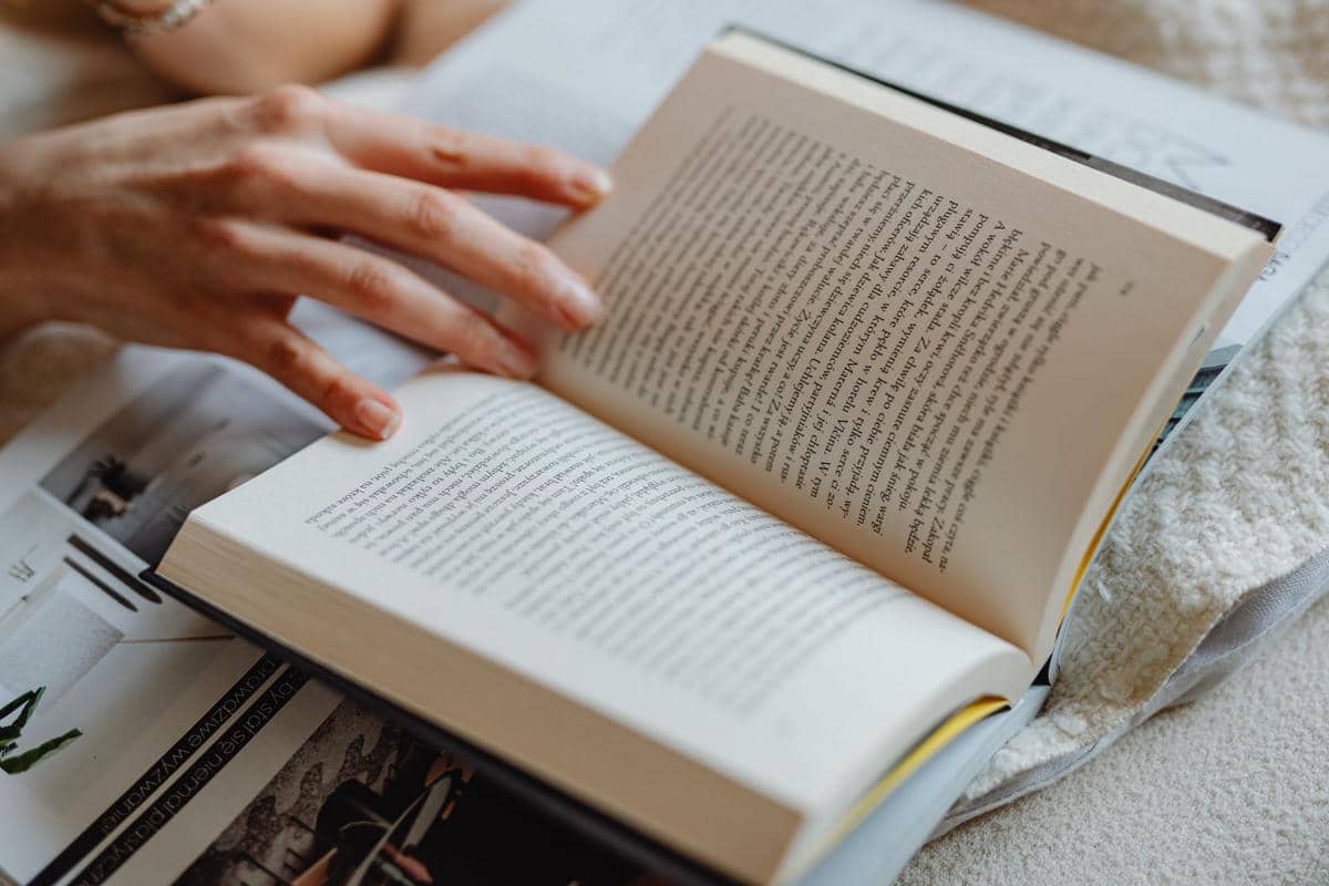 Ilustrasi buku yang terbuka sebagai simbol aktivitas membaca, belajar, dan membuka wawasan melalui halaman bacaan.