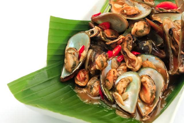 Ilustrasi tumis kerang hijau dengan cangkang hijau tua dan daging kerang, disajikan sebagai hidangan laut di latar putih.
