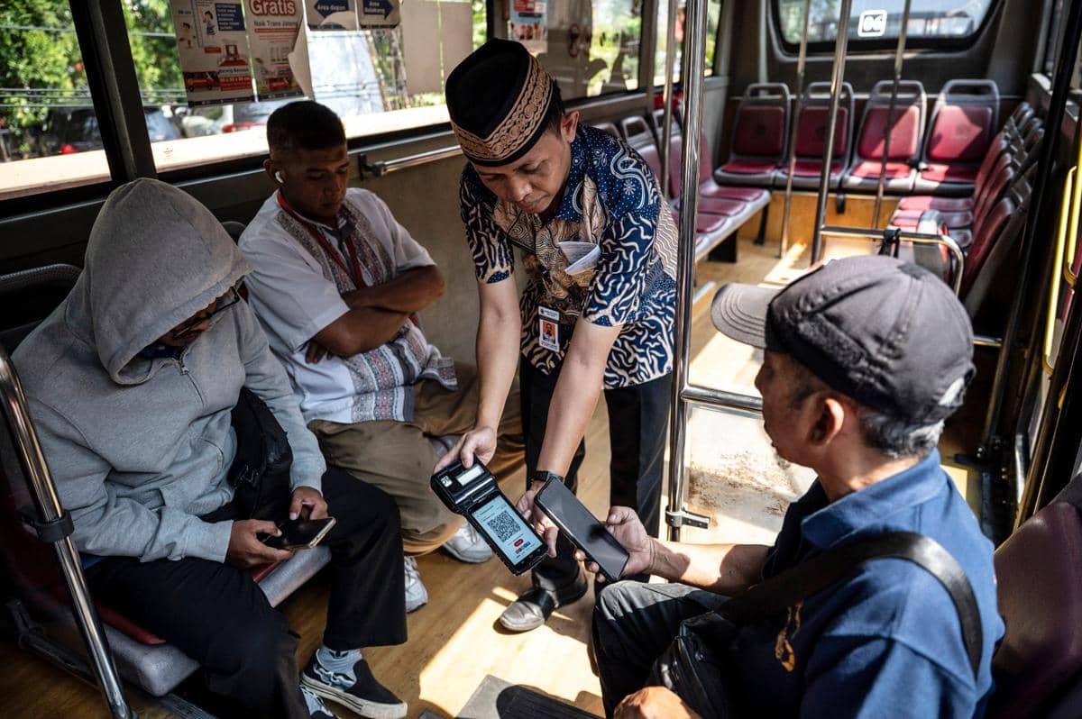 Penumpang memindai kode QR untuk membayar tiket bus Trans Jateng di Semarang, Jawa Tengah. (ANTARA FOTO/Aprillio Akbar)
