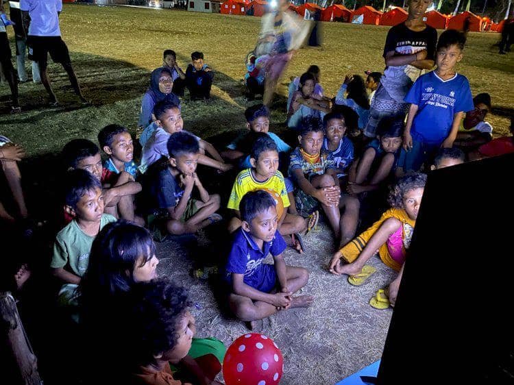 Sejumlah anak korban gempa Nagekeo duduk bersama menonton televisi di dalam posko pengungsian sementara.