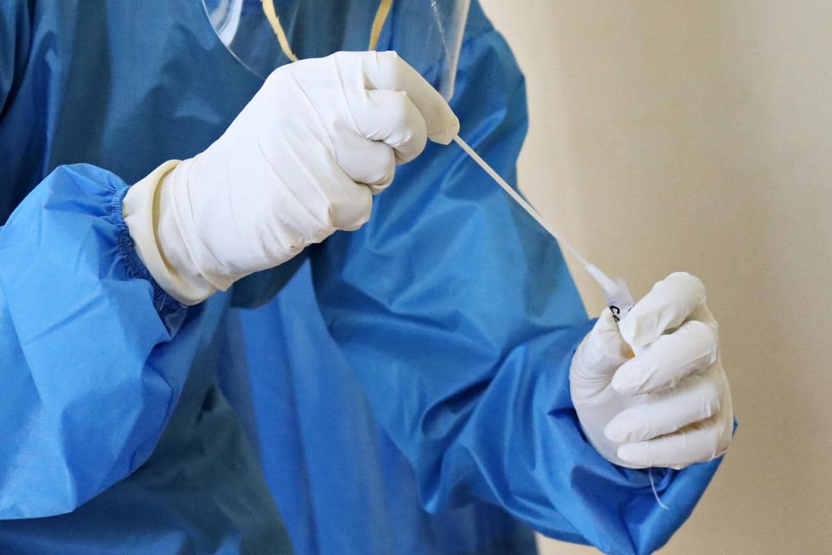ilustrasi pekerja laboratorium memegang alat swab test