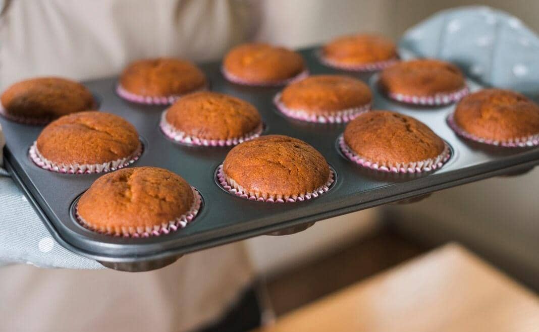 Ilustrasi muffin yang telah dipanggang dengan permukaan cokelat keemasan dan bagian atas mengembang merata.