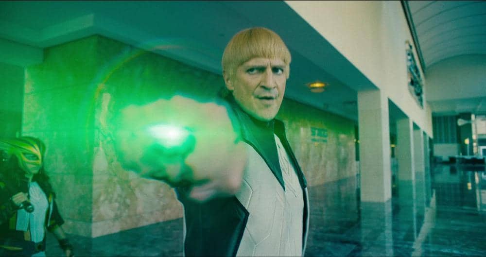 Guy Gardner mengenakan seragam Green Lantern hijau berlogo putih, berdiri dengan ekspresi serius dalam film Superman.