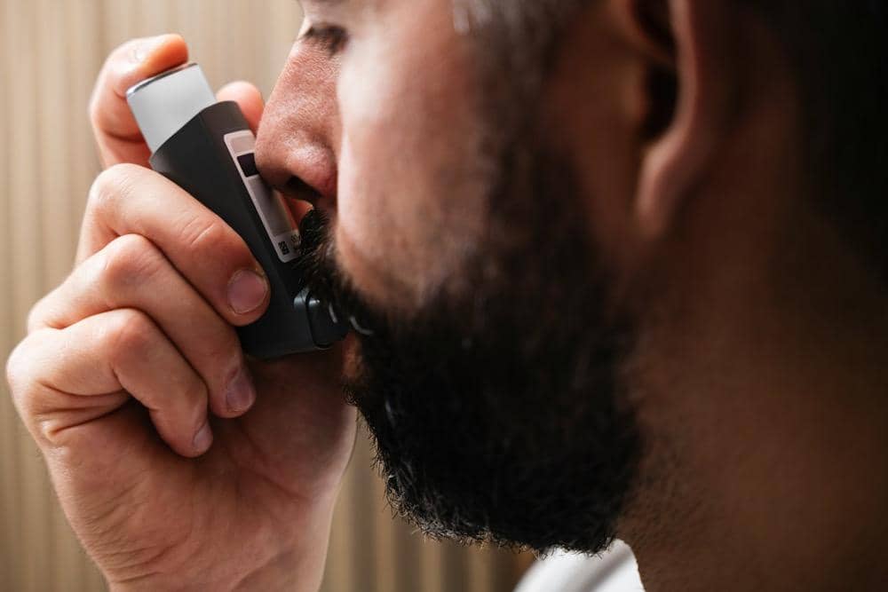 ilustrasi penderita asma sedang menggunakan inhaler