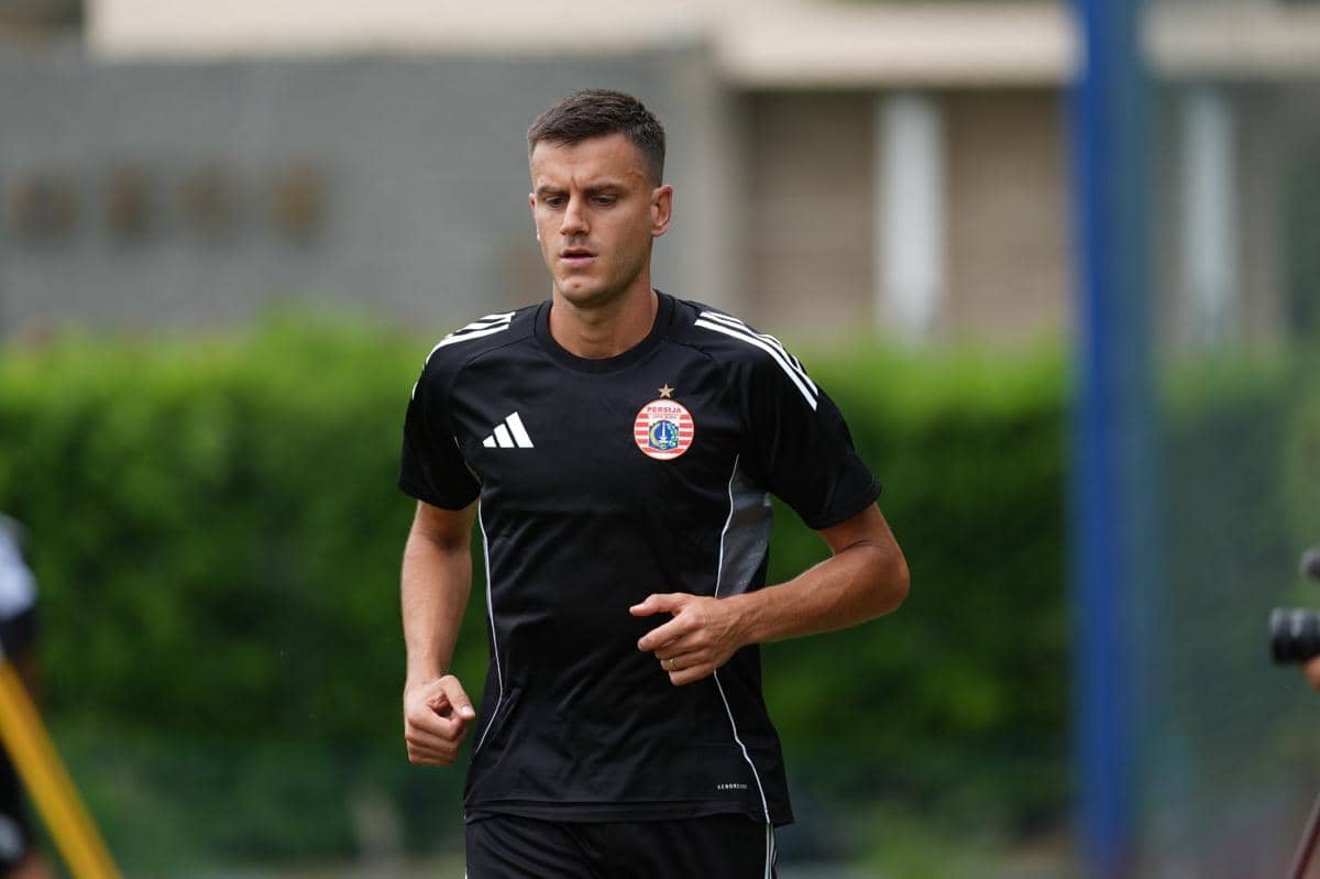 Potret Alexander Jeremejeff sebagai pemain anyar Persija, tampil mengenakan jersey klub dalam materi pengumuman resmi.