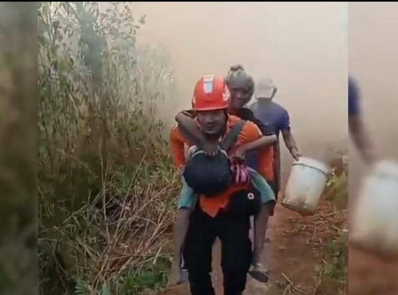 Petugas Satgas Karhutla Mamasa, Farid, menerobos kepungan asap untuk mengevakuasi nenek Martha saat kebakaran lahan.