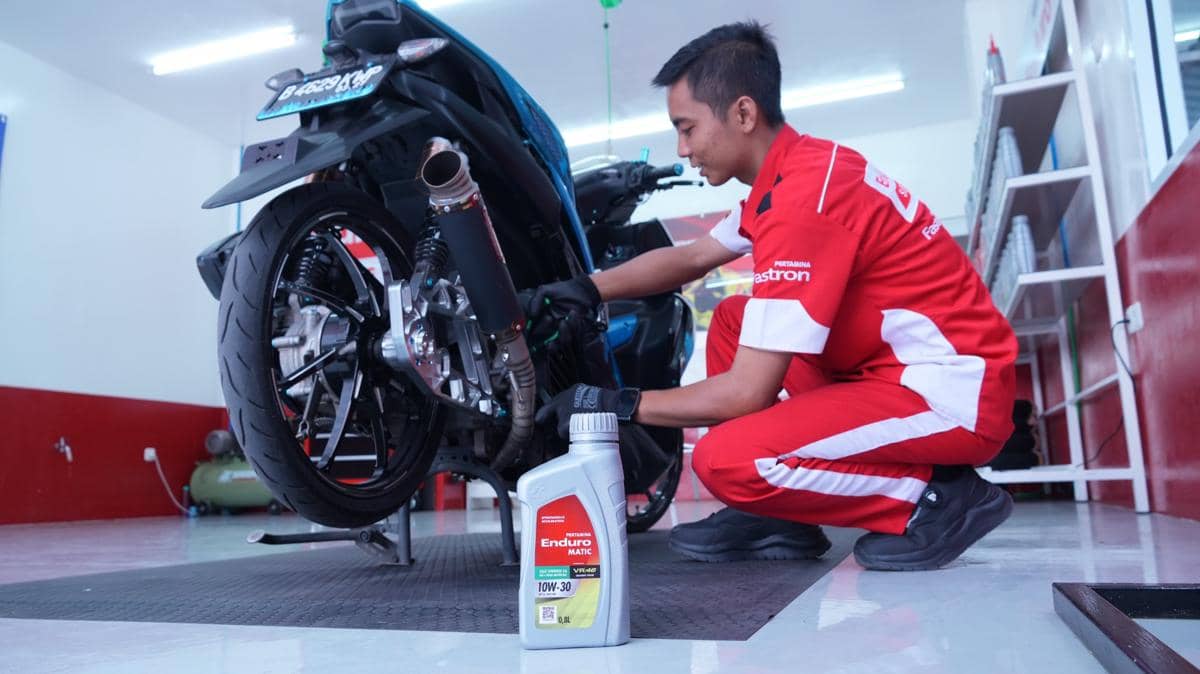 Mekanik Enduro Service memeriksa dan mengganti oli mesin sepeda motor di area SPBU Pertamina Ahmad Yani.