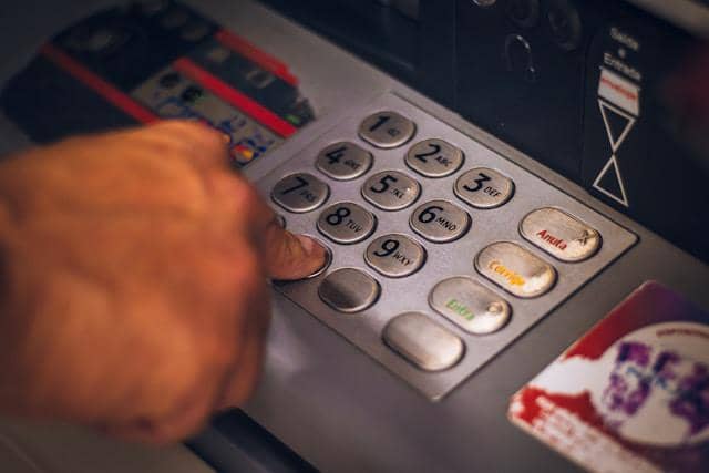 ilustrasi menekan nomor PIN pada mesin ATM