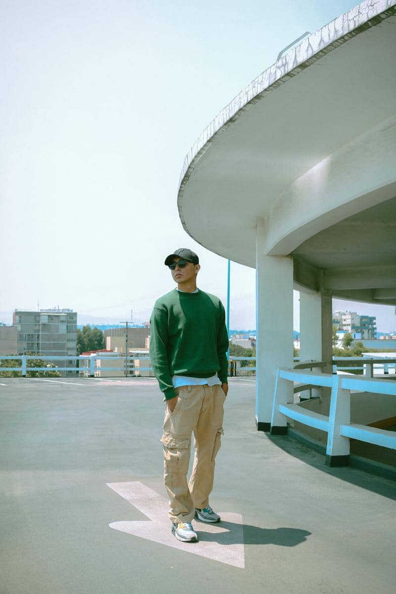 Cowok memakai crewneck sweater dan celana cargo