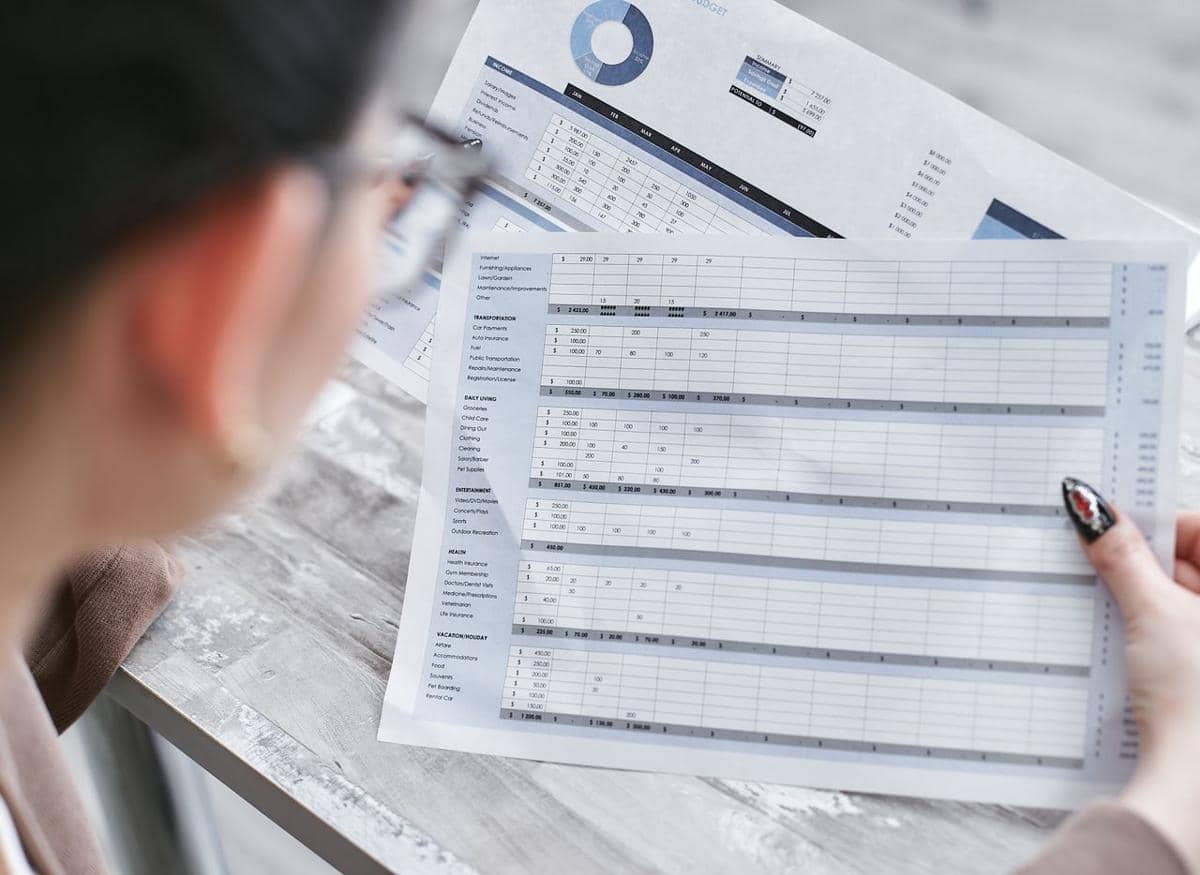 ilustrasi seorang pebisnis wanita sedang meninjau spreadsheet keuangan dengan bagan dan grafik