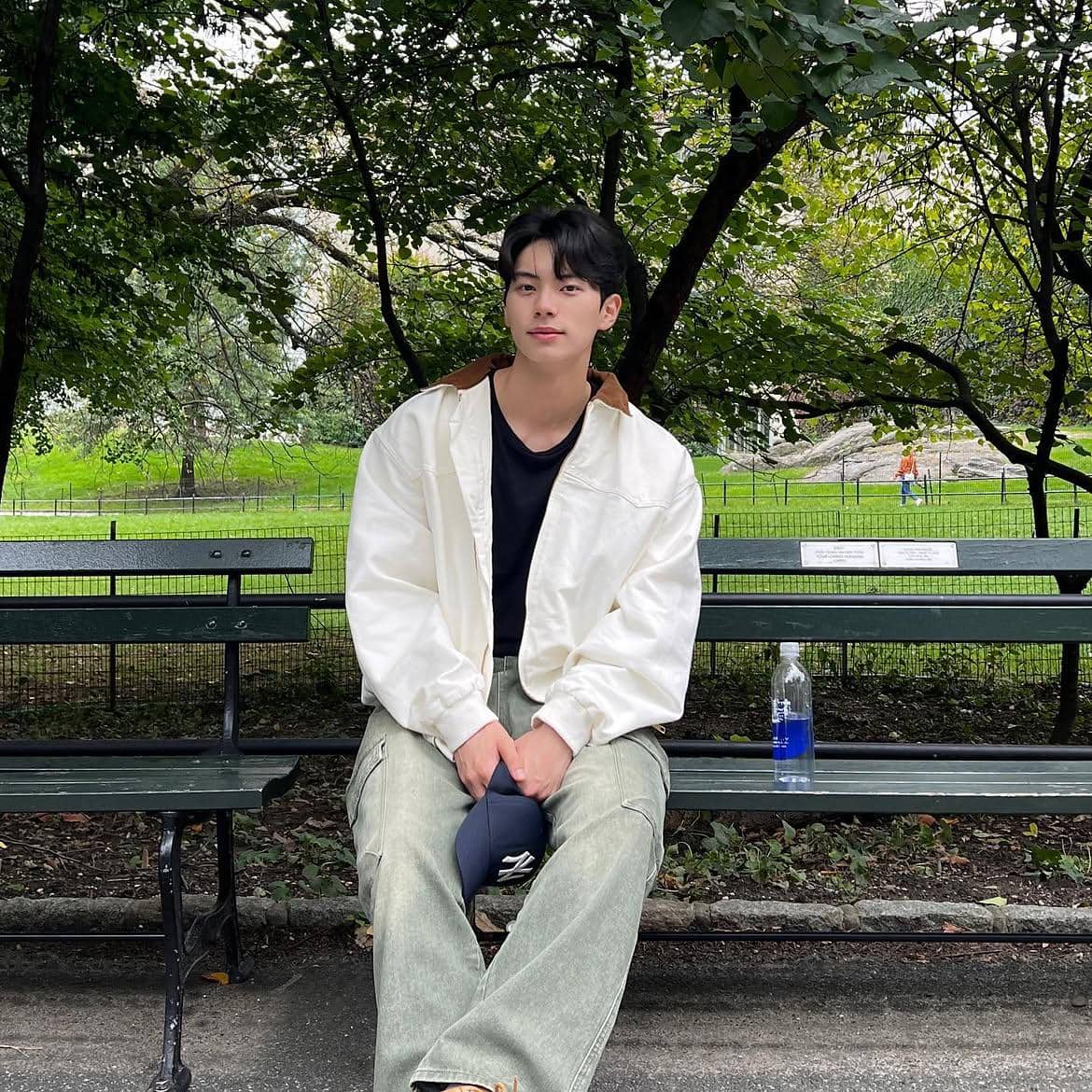 Lee Chae Min mengenakan padu padan outfit serba putih dengan gaya kasual yang rapi dan modern.