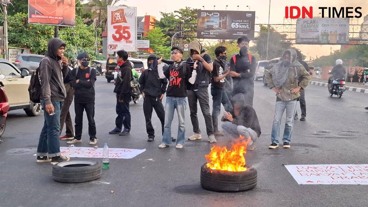 Aliansi Mahasiswa Berlawan saat menggelar aksi unjuk rasa sambil membakar ban bekas di depan Kampus Menara Phinisi UNM Jl A.P Petterani Maka