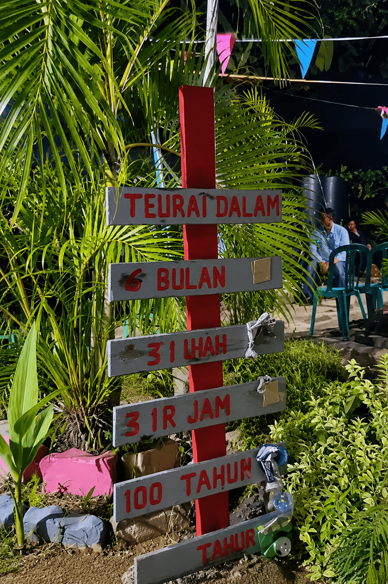 Taman warga dengan tanaman hias dan jalur setapak yang dibangun di bekas area tempat sampah di Desa Bakauheni, Lampung Selatan.