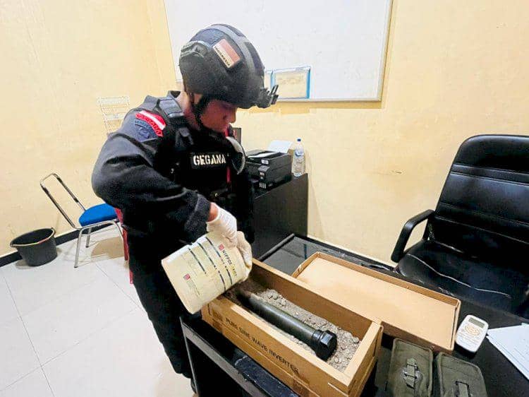 Personel Tim Jibom Gegana memeriksa peluru dan granat yang diserahkan seorang petani kepada Polres Malaka.