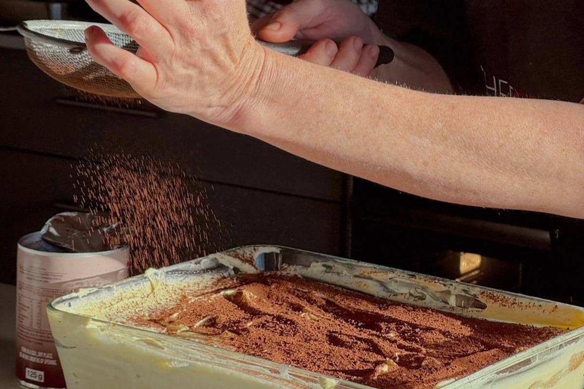 ilustrasi menaburi bubuk hojicha sebagai topping tiramisu