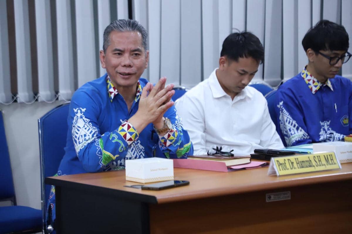 Prof. Dr. Hamzah menyerahkan berkas pendaftaran calon Rektor Unila 2027 kepada panitia di ruang layanan kampus.