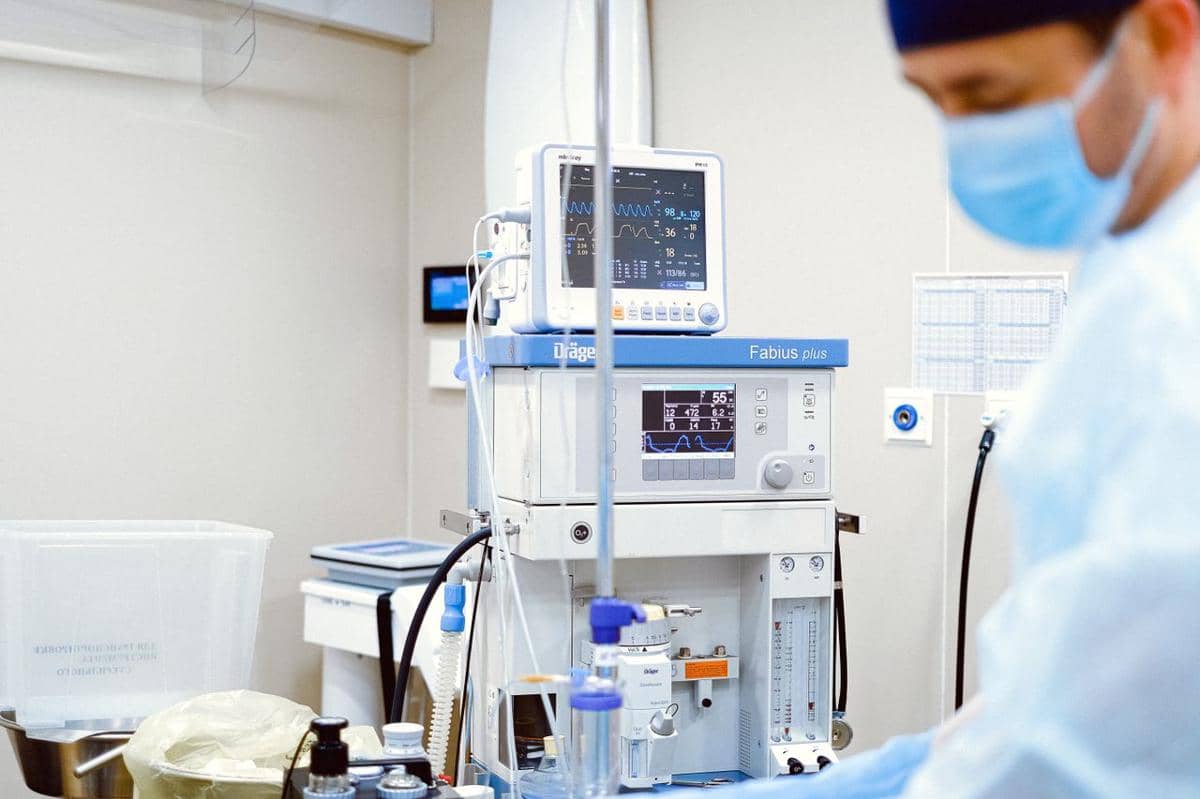 Peralatan medis dan monitor pasien di ruang ICU rumah sakit, menggambarkan fasilitas perawatan intensif.