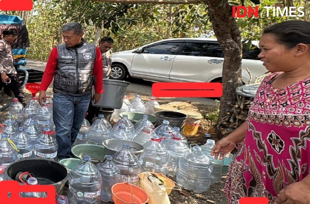 Warga Kalibagor membawa botol galon untuk mengambil air bersih di Polsek Kalibagor, Banyumas, demi memenuhi kebutuhan air.
