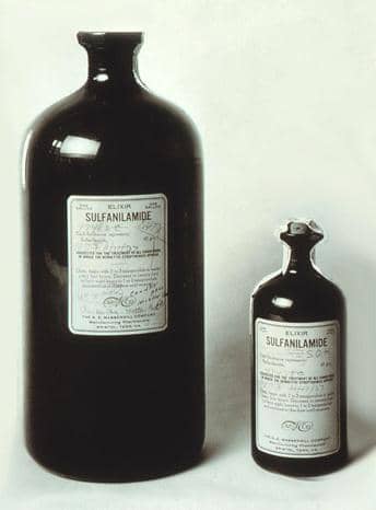 Botol obat Elixir Sulfanilamide berwarna cokelat dengan label produk, dipotret pada latar belakang putih.