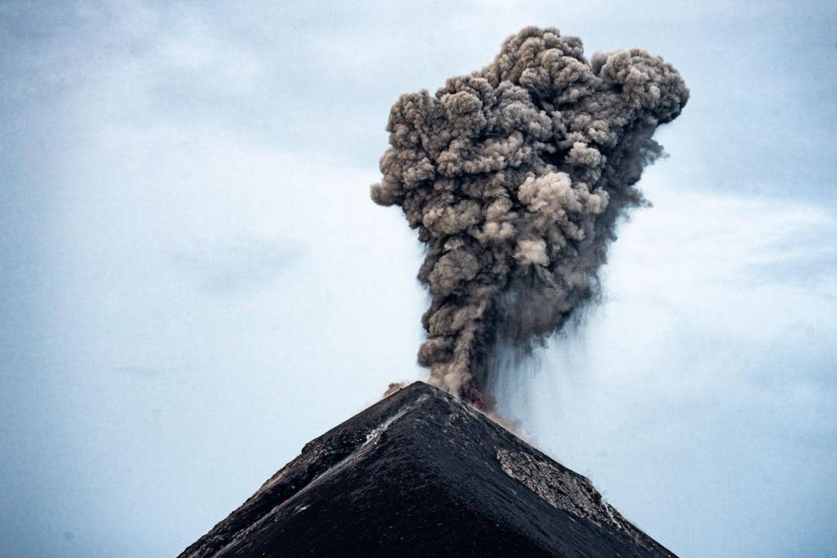 Asap abu-abu pekat dan tebal membubung tinggi ke langit dari kawah utama yang berada di puncak gunung berapi.