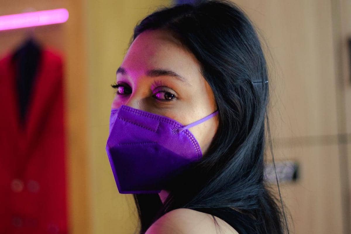 Ilustrasi beberapa masker KN95 berwarna mencolok dengan variasi warna cerah tersusun di atas latar polos.