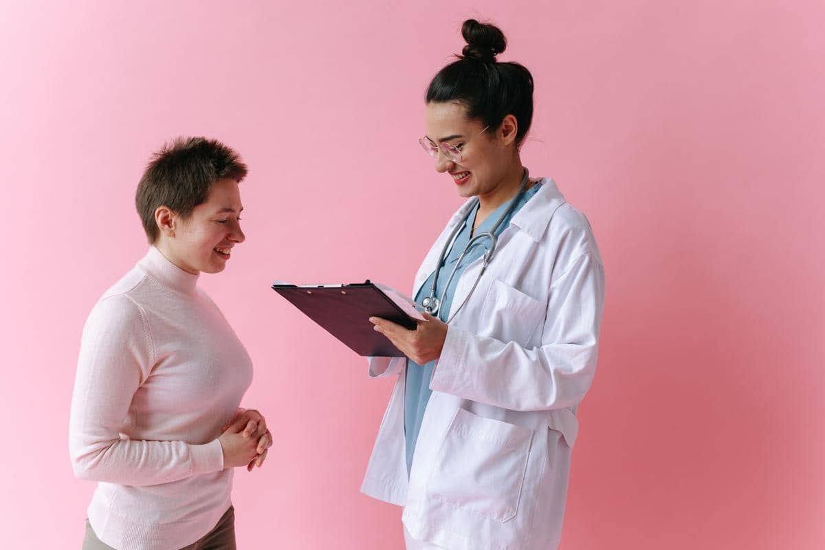 Seorang dokter menjelaskan hasil pemeriksaan Pap smear kepada pasien perempuan di ruang konsultasi klinik.