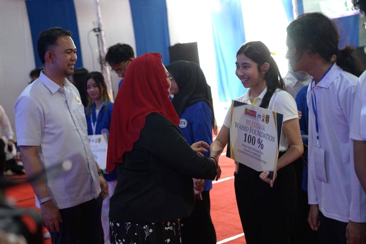 Yenny Wahid menyerahkan beasiswa kepada seorang mahasiswi sebagai penerima bantuan pendidikan secara langsung.