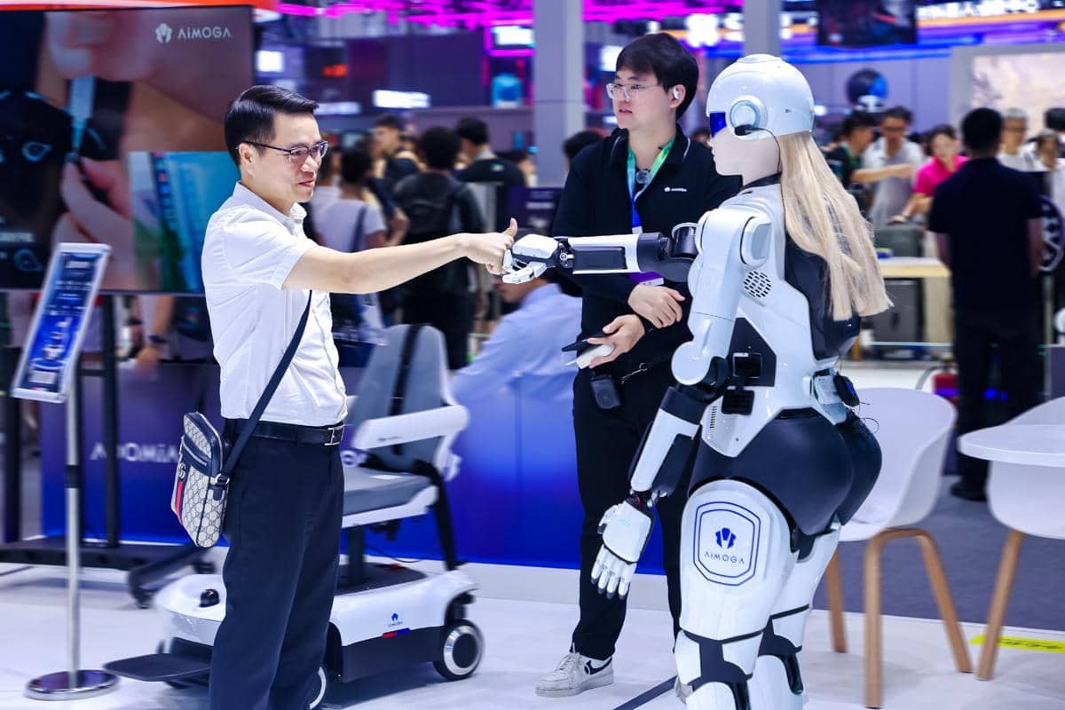 Robot humanoid Mornine berdiri di area dalam ruangan dengan tampilan tubuh putih dan aksen hitam.