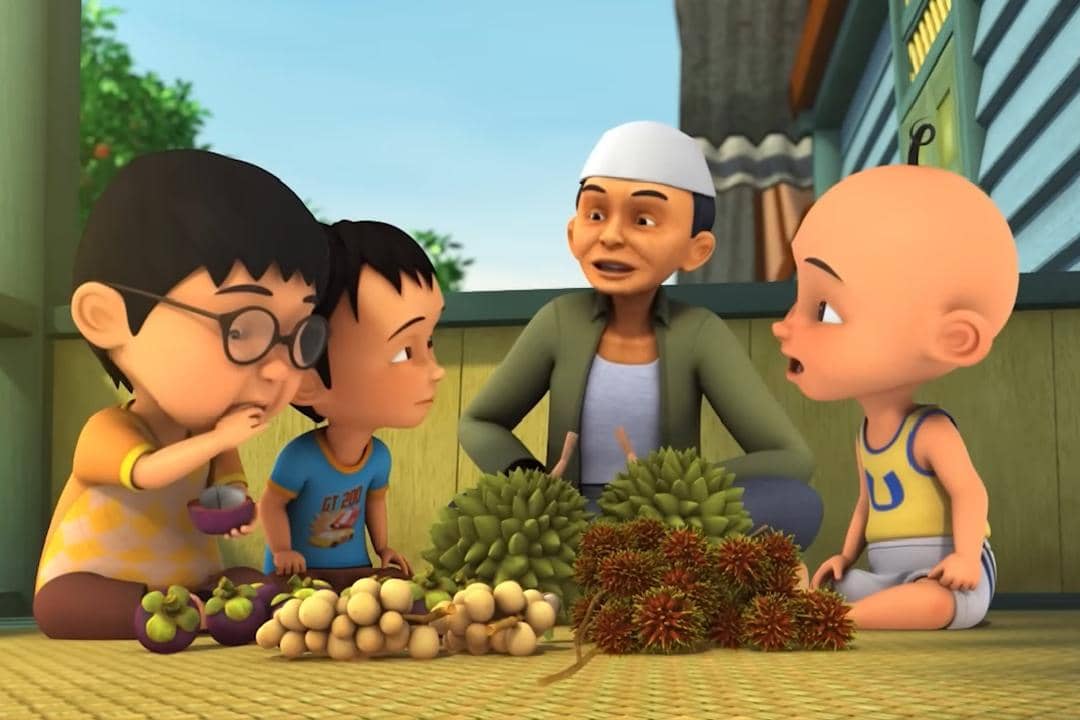 Tok Dalang duduk bersama para bocah yang asyik makan buah di teras rumahnya