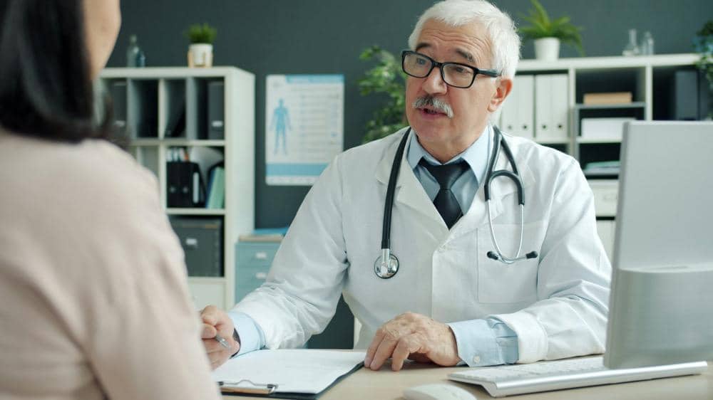 Seorang perempuan sedang berkonsultasi dengan dokter