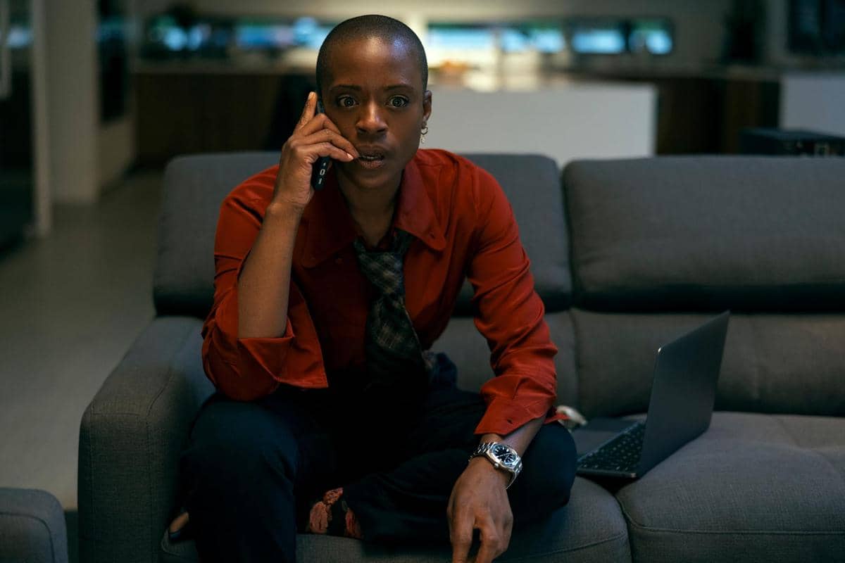 T'Nia Miller tampil dalam adegan serial Netflix The Fall of the House of Usher dengan latar ruangan gelap.