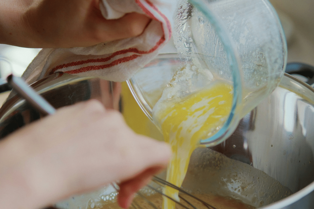Sepotong lemon bar berlapis cokelat dengan potongan stroberi di atasnya, disajikan sebagai ilustrasi hidangan penutup.
