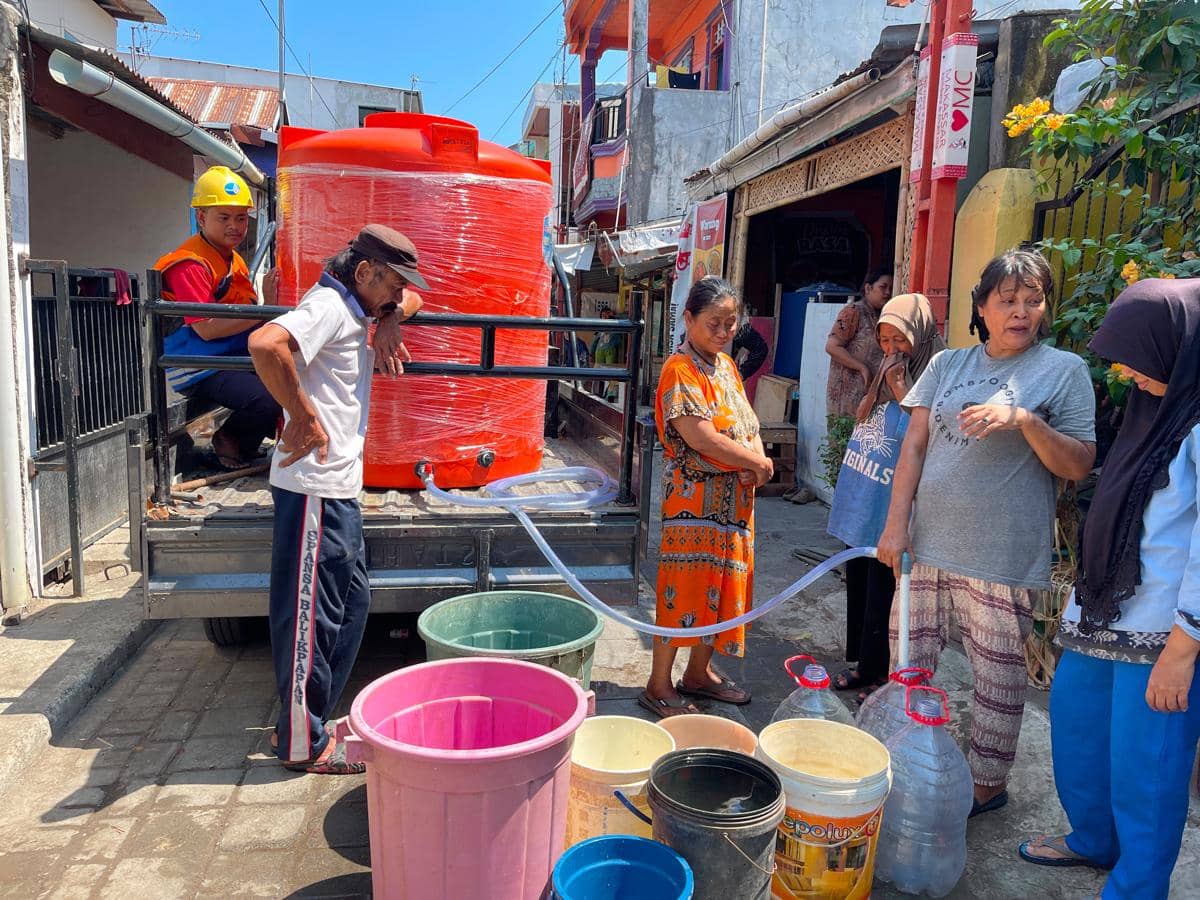 Mobil pickup bertandon Perumda Air Minum Kota Makassar menyalurkan bantuan air bersih di lorong sempit Karuwisi Utara.