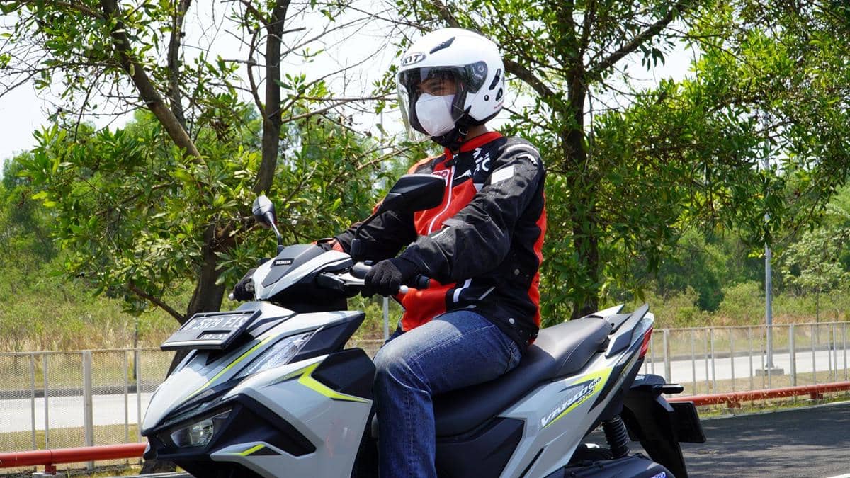 Pengendara sepeda motor mengenakan helm dan perlengkapan berkendara lengkap untuk menunjang keselamatan di jalan.