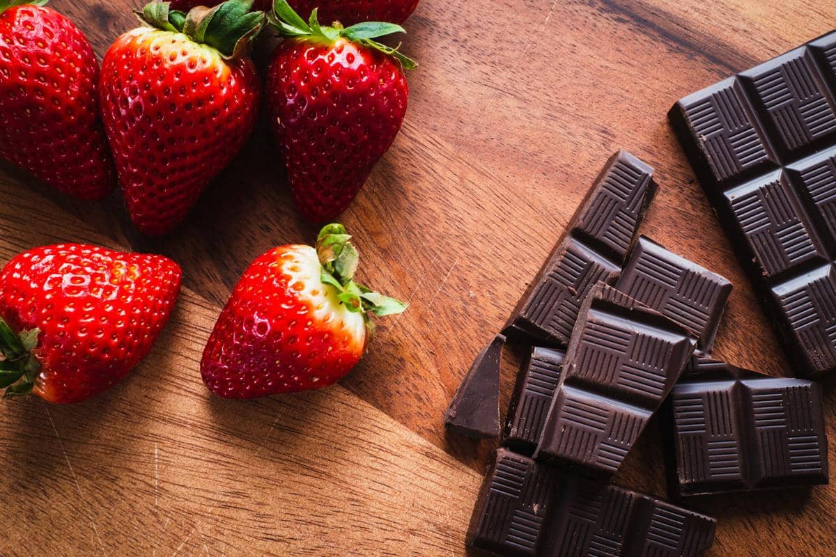 Ilustrasi stroberi cokelat, camilan manis berupa buah stroberi yang dilapisi cokelat untuk sajian penutup.