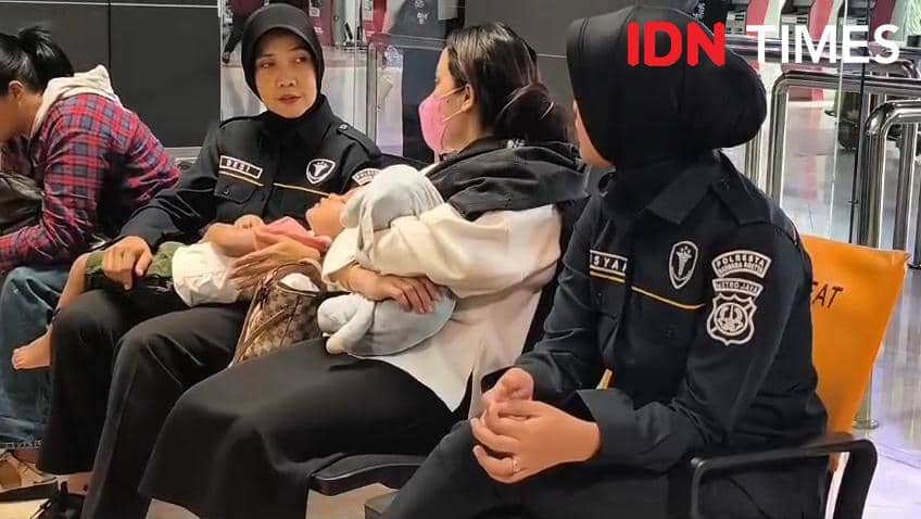 Seorang ibu menggendong anak balita terlantar selama dua hari di Bandara Soekarno-Hatta akibat abu vulkanik Anak Krakatau.