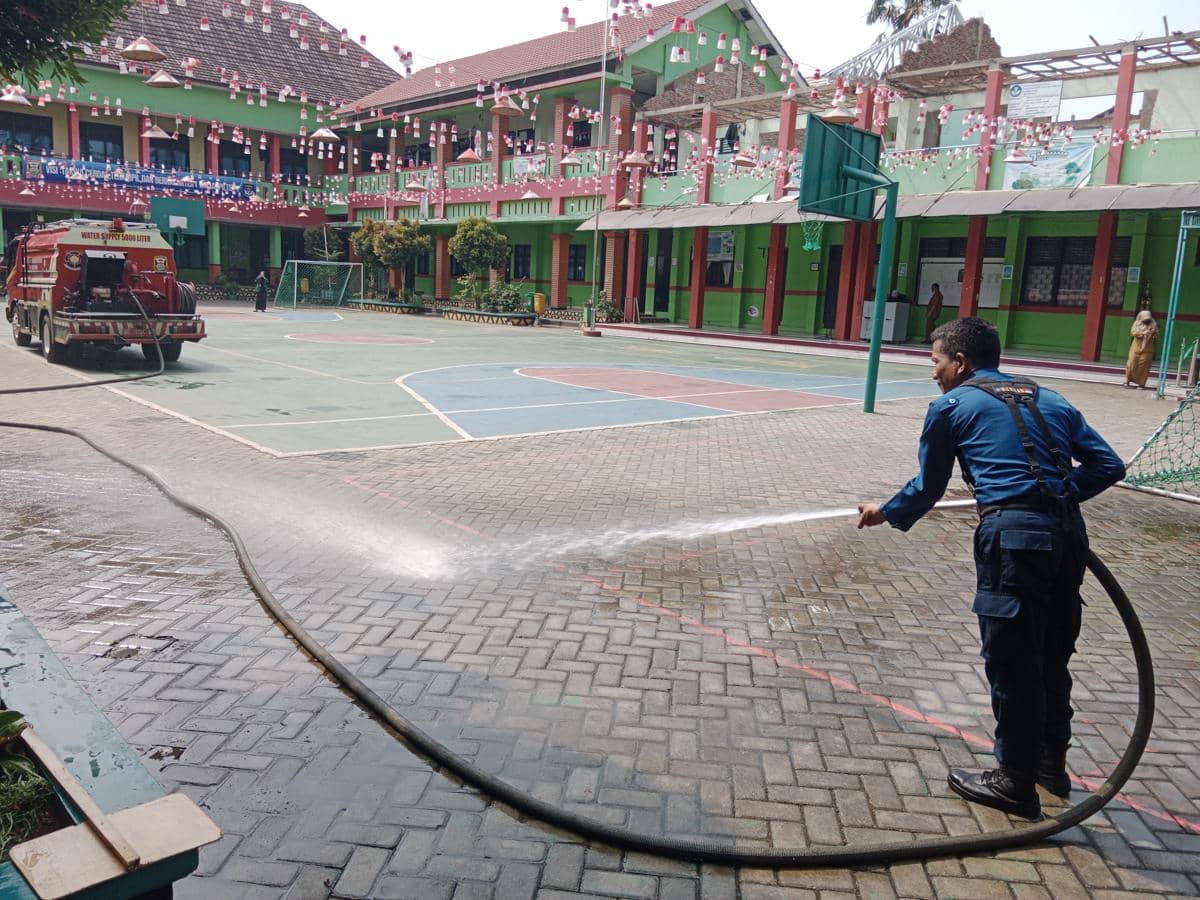 Petugas Damkarmat Bandar Lampung saat membersihkan Abu Vulkanik di Sekolah.