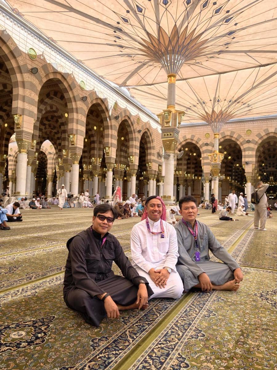 Sejumlah anggota Grind Boys berpose bersama saat menjalankan ibadah umrah, mengenakan pakaian serba putih di area masjid suci.